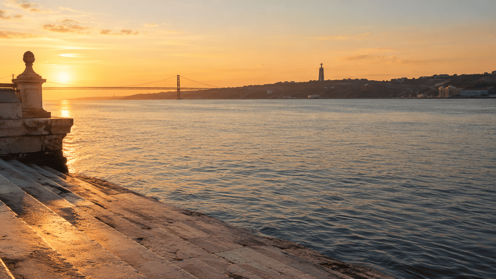Stone steps descending into the Tagus on Lisbon’s riverfront at golden hour